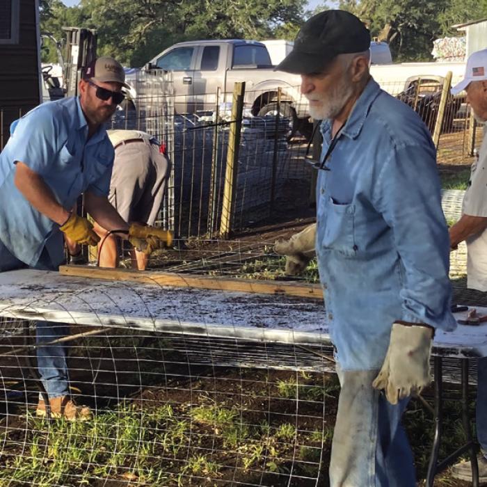 Scott Willey and Glenn Altwein cut lengths of fencing for Liberty Trees as Daniel Lewis unrolls another section of wire.