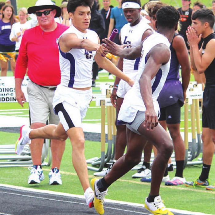 La Grange’s Gerald Rodriguez hands off to CJ Davis during La Grange’s 4x400 relay, which they ended up winning. Photo by Jeff Wick