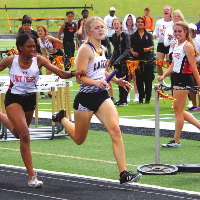 La Grange’s Hailey Bass came from behind to nip Smithville’s Kiyanna Sampson at the finish line on the final leg of the 4x400 relay. Photo by Jeff Wick