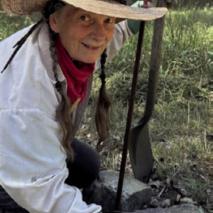 Mary Kirby cleaning and repositioning one of the multitude of markers to the “Unknown” heroes interred at Pin Oak Historical Cemetery.