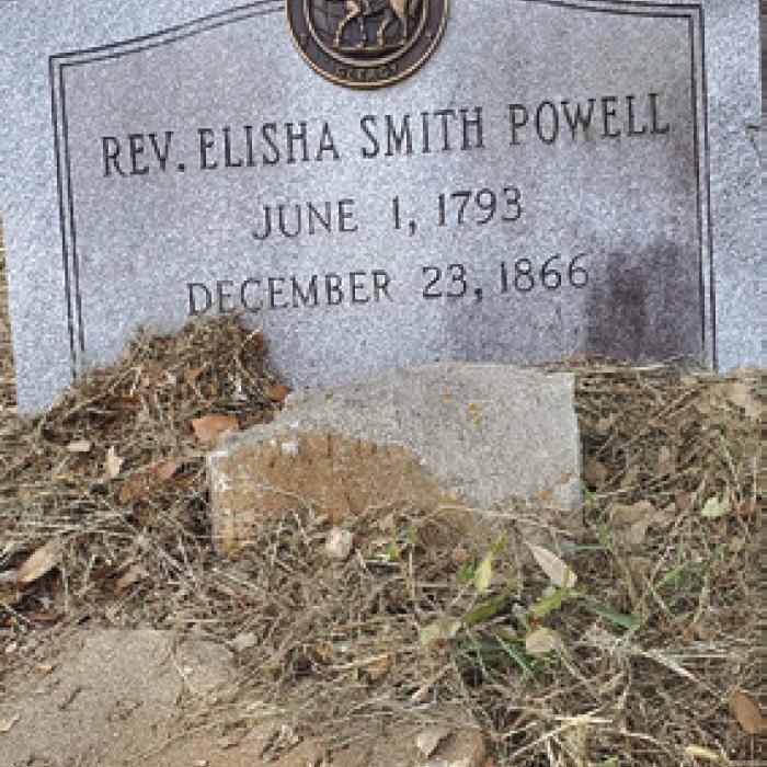 Recent granite tombstone beside the crumbling cement original.