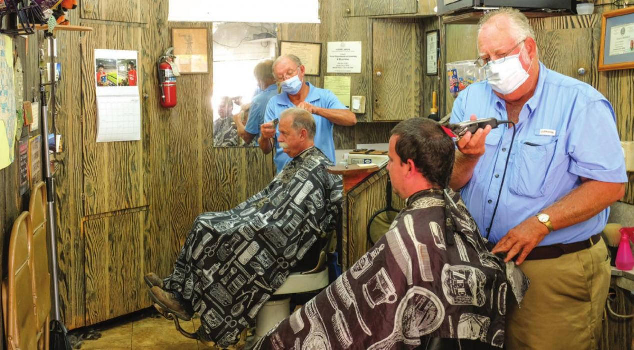 Barbers Ken Jurecka and Floyd Weishuhn were back in business on the La Grange Square Friday morning. Barber shops and salons have been closed for nearly two months during the coronavirus pandemic. Photo by Andy Behlen