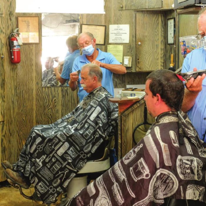 Barbers Ken Jurecka and Floyd Weishuhn were back in business on the La Grange Square Friday morning. Barber shops and salons have been closed for nearly two months during the coronavirus pandemic. Photo by Andy Behlen