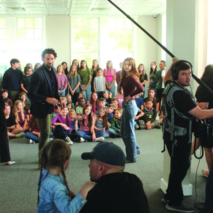 Director Shawn Welling talks to his daughter Emmarain, who stars in the movie “The Sound of Willow,” which was filming at the old red brick schoolhouse in Fayetteville last week. In the background are dozens of Fayetteville students who were used as extras in the movie. The movie also stars Lee Majors, who was one of the biggest TV stars of the 1960s, 70s, and 80s. The crew will also be filming at Festival Hill. Photo by Jeff Wick