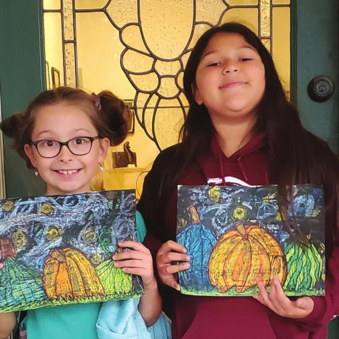 Two proud, young artists show their artwork created in the ARTS Art After School Program.