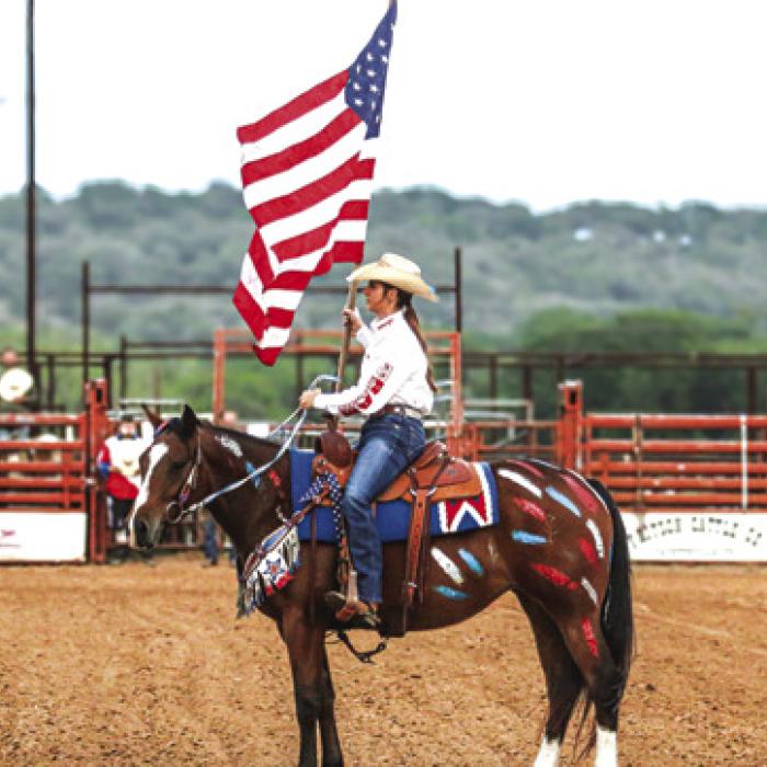 Teagan Kallus with the American Flag during the rodeo.
