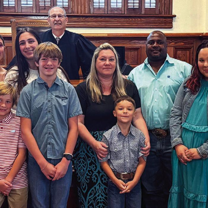 The Greenwood, Jackson and Ellis families pose for a photo graph with District Judge Jeff Steinhauser following proceedings last Thursday, May 28. Photo by Andy Behlen