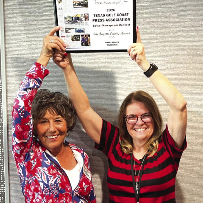 Record owners Nonnie Barton, left, and Regina Keilers, right, hold aloft the Sweepstakes trophy after The Fayette County Record was crowned the top large circulation newspaper by The Texas Gulf Coast Press Association at their annual convention in Port Lavaca Saturday.