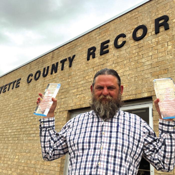 Record reporter Andy Behlen shows off the Texas Gulf Coast Press Association Reporter of the Year award he won Saturdday for a collection of stories he wrote in 2025, and his South Texas Press Association Photographer of the Year Award he won for a collection of photos he took in 2025.