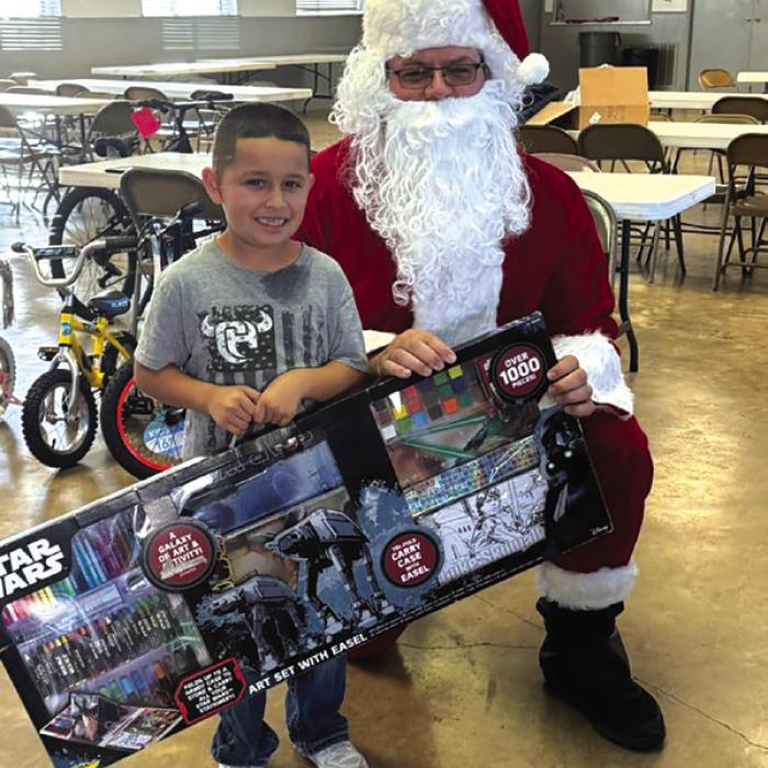 A local child with his present from Santa at a Deputy Santa pick-up location last year.
