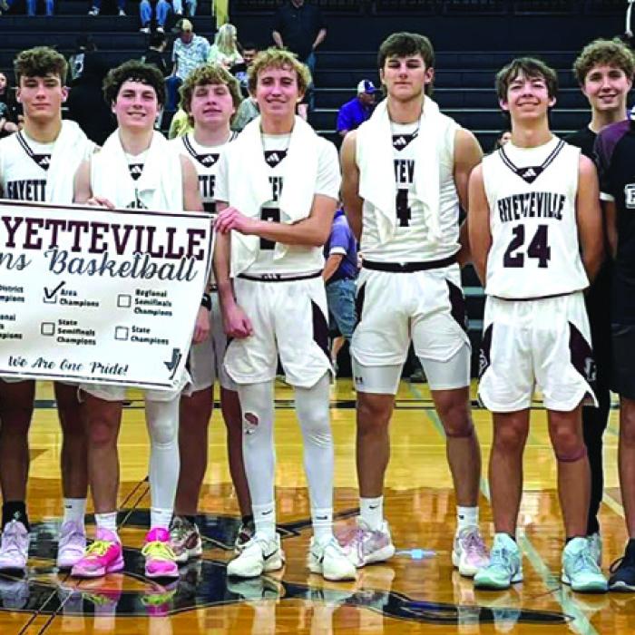 The members of the Fayetteville basketball team celebrate their Area title after Friday’s victory in Seguin.