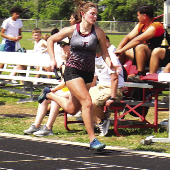 Fayetteville’s Kayme Schley runs during one of the relays at the district meet this week. Photo by Ann Pape