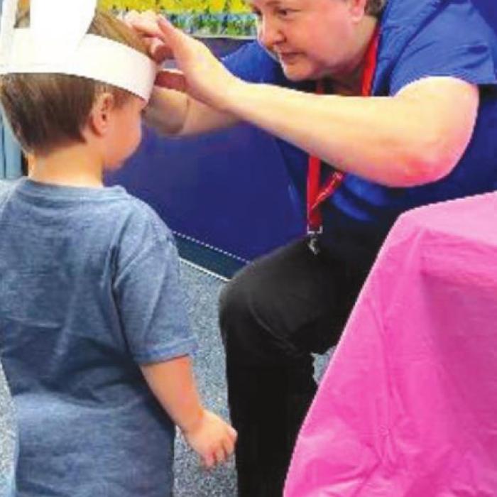 Parent Educator, Windi Raphael, helping children put on their bunny ears.