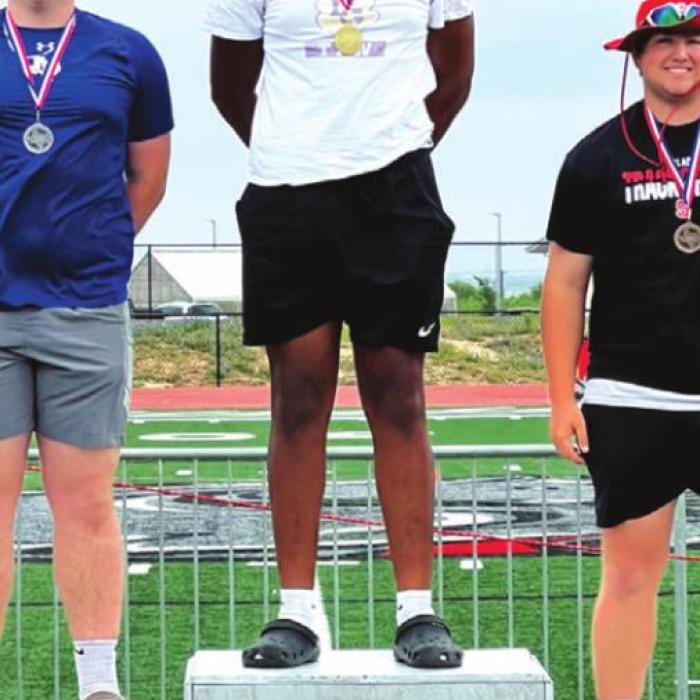 Jaren Woods atop the podium after winning the discus at area.