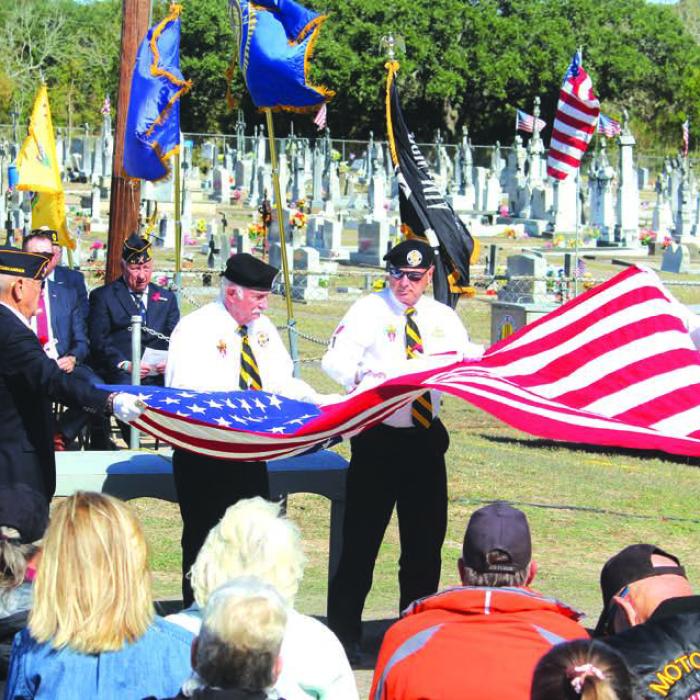 Andy Janda and Danny Vyvjala assist other veterans in a special folding of the flag during Sunday’s ceremony.