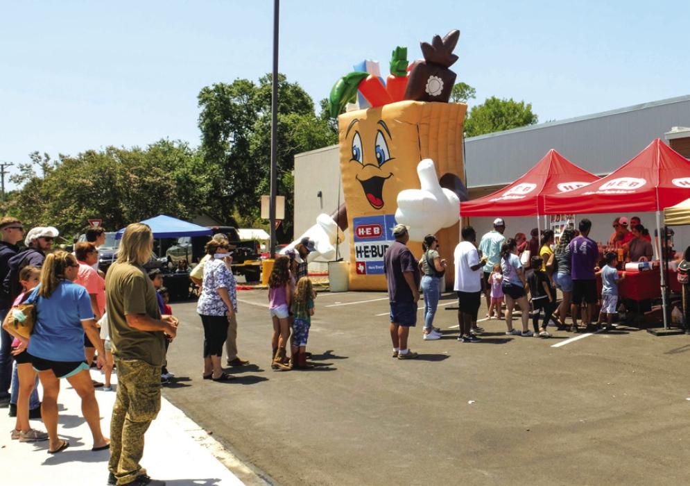 A crowd of folks stand in line for free snow cones at H-E-B on Saturday, June 22. Photo by Andy Behlen