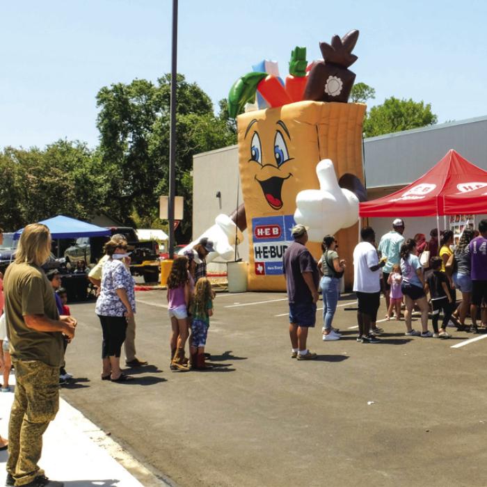 A crowd of folks stand in line for free snow cones at H-E-B on Saturday, June 22. Photo by Andy Behlen