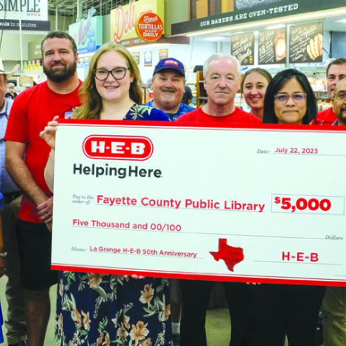 Kelly Ceder-Ryba, Carol Perales and Allison MacKenzie of the Fayette Public Library accept a $5,000 donation from the staff of the La Grange H-E-B store.
