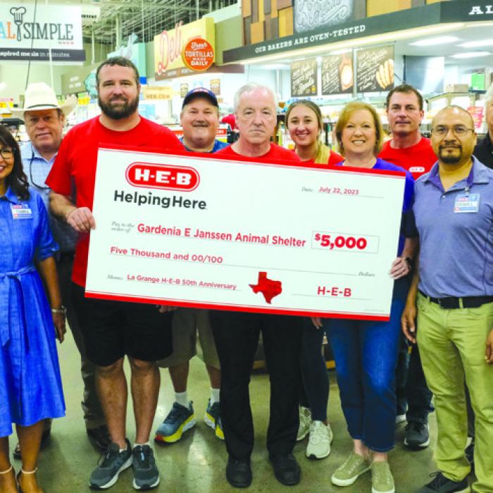 Volunteer coordinator Lisa Slinkard of Gardenia E. Janssen Animal Shelter accepts a $5,000 donation from the staff of the La Grange H-E-B store.