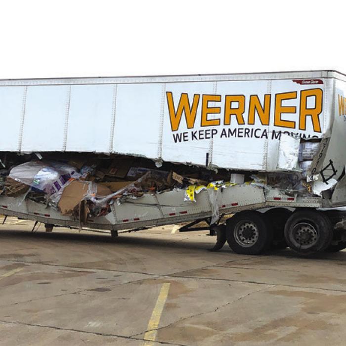 After getting split open after it hit a guardrail in the Tuesday morning fog this truck (also pictured on the front at that scene), was hauled to the Sutherland’s parking lot to await unloading of its cargo. Photo by Bobby Bedient
