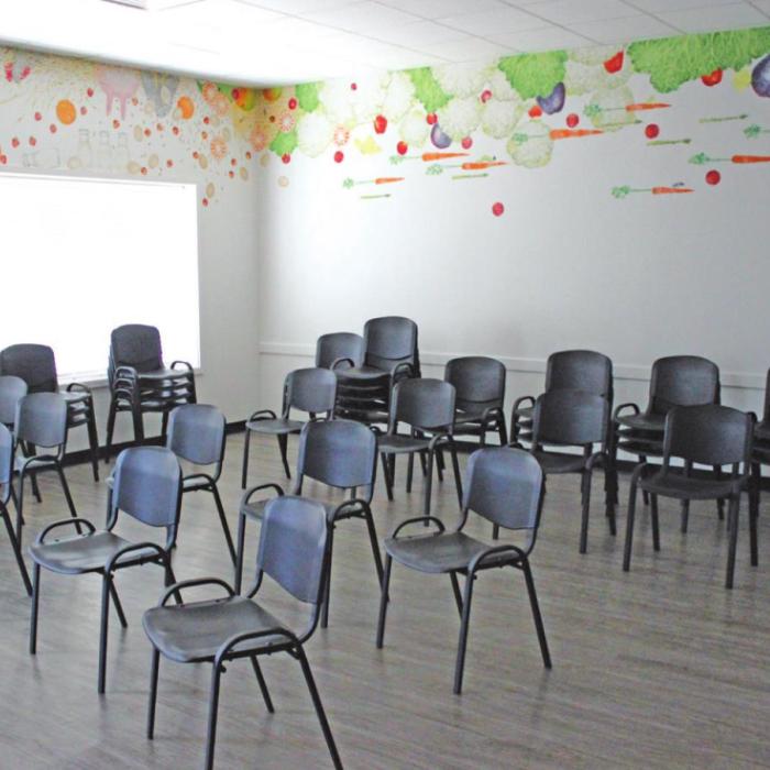 The new AMEN food pantry, which opened last year, has a brand new waiting area (complete with a veggie-themed mural donated by a Round Top artist) that has yet to be used by clients because of pandemic precautions. Clients instead wait in their cars until called to come in to shop for food. Photo by Jeff Wick