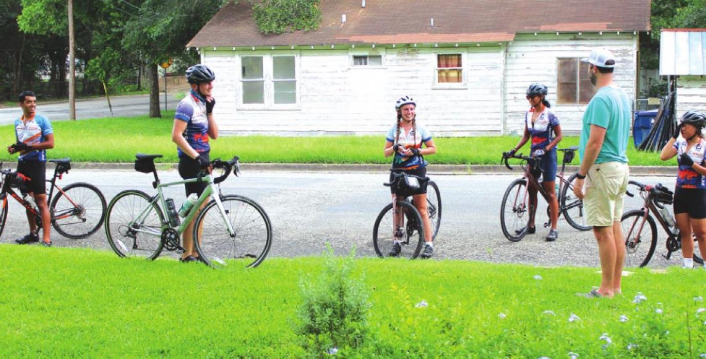La Grange’s Bryan Kerr goes out to meet the cyclists as they arrived at his house last Monday for a stopover amidst the Texas 4000. Photo by Jeff Wick