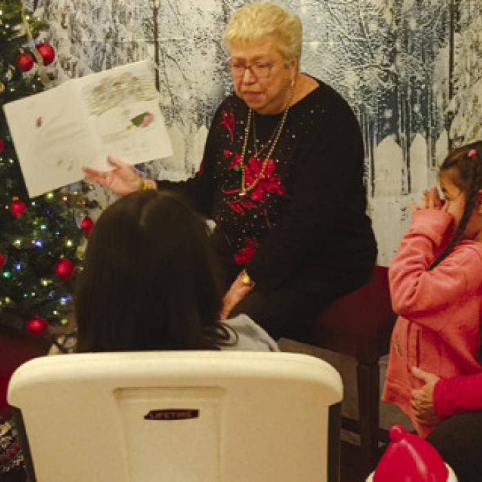 Dinah Breeden reading a Christmas story to the children at the Community Christmas Party.
