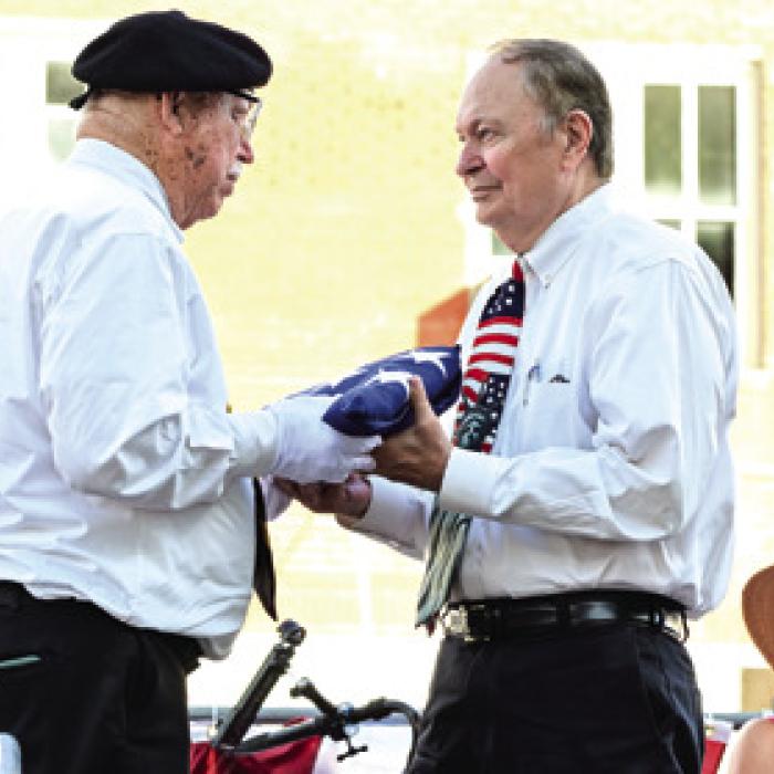 Local veteran Andy Kruppa presents a folded American Flag to Fayette Co. Judge Dan Mueller. Photo by Stephanie Steinhauser