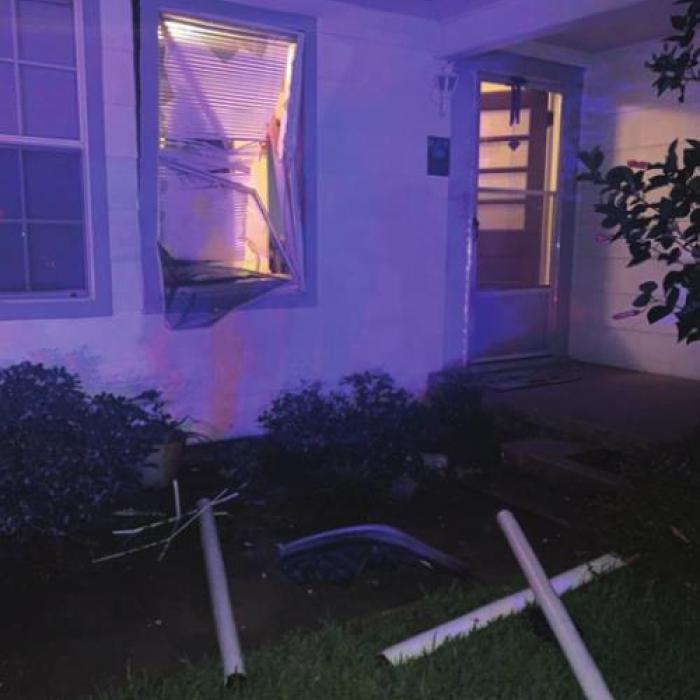 The impact snapped some of the barricade poles off at the ground and sent them flying, breaking a window of the house.