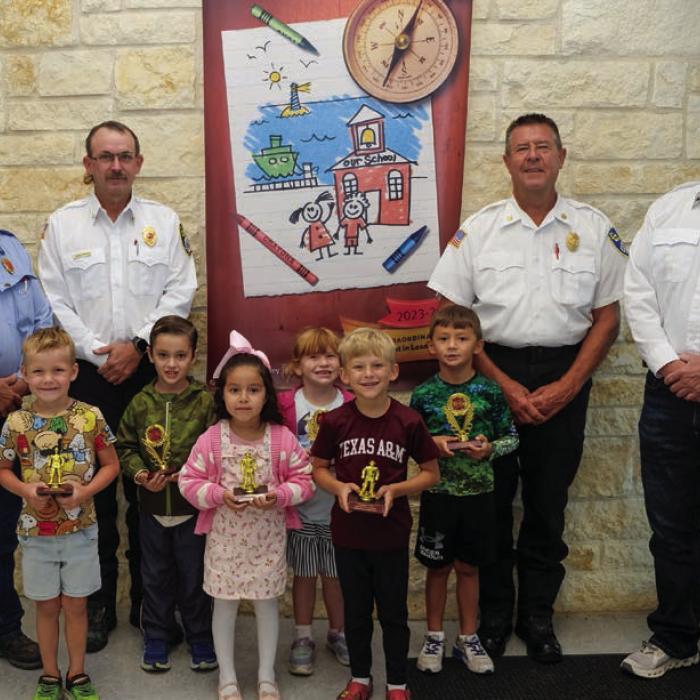 Fire poster winners and honorable mentions from Pre-K and kindergarten at La Grange Elementary went to (front, from left) Easton Roberts-Oppermann, Mireya Salinas, Truitt Ulrich, (middle) Lochlan Stewart, Jenna Long and Brooks Adamcik. They are pictured with (back) Kenneth Chovanec, Glen Knigge, Frank Menefee, and Todd Johnson of the La Grange Volunteer Fire Department. Photo by Andy Behlen