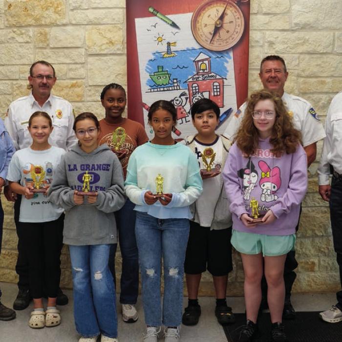 Fire poster winners and honorable mentions from fifth and sixth grade at La Grange Elementary went to (front, from left) Leah Gulash, Kimberlynn Sheppard, Sophia Musselwhite, (middle) Lilly Herzog, Alani Black and Benny Casteneda. They are pictured with (back) Kenneth Chovanec, Glen Knigge, Frank Menefee, and Todd Johnson of the La Grange Volunteer Fire Department. Photo by Andy Behlen