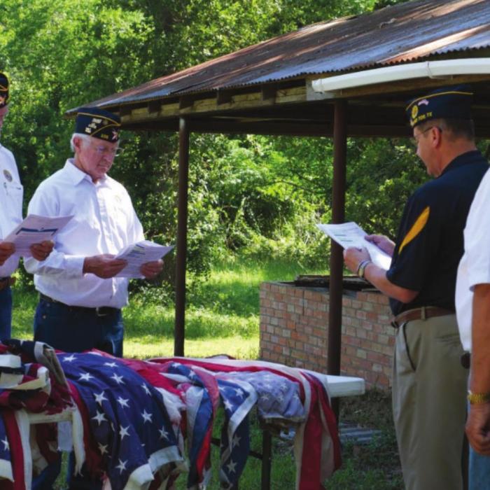 Adjutant Bruce Bockhorn presents the flags for inspection to 1st Vice Commander Marvin Wessels and Financial Officer Frank Williams as Post Commander Lyn Reavis looks on.