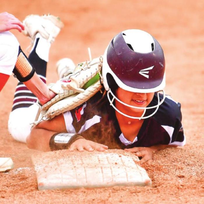 Flatonia’s Elzah Herrera, baserunner for Annie Charanza, dives back to first base after attempting to advance to second base in action between the Schulenburg Shorthorns and Flatonia Lady Bulldogs. Photo by Stephanie Steinhauser