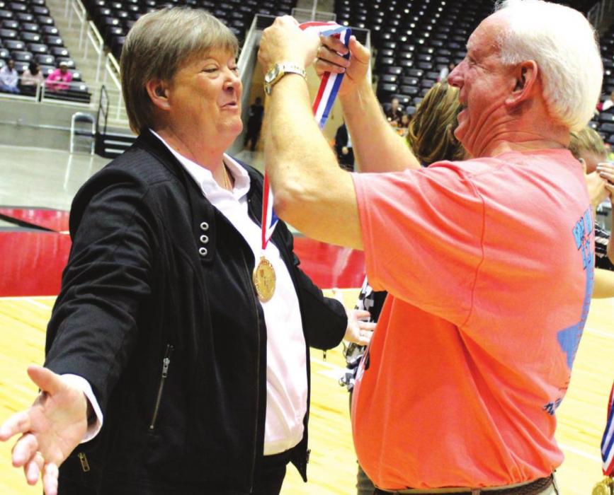 Former Round Top-Carmine superintendent Mark Conley drapes a state championship medal over Tanya Nygrin’s head after she and the Cubettes won the 2013 state title.