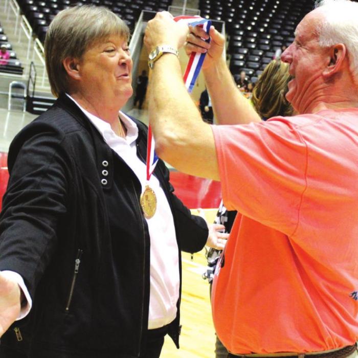 Former Round Top-Carmine superintendent Mark Conley drapes a state championship medal over Tanya Nygrin’s head after she and the Cubettes won the 2013 state title.