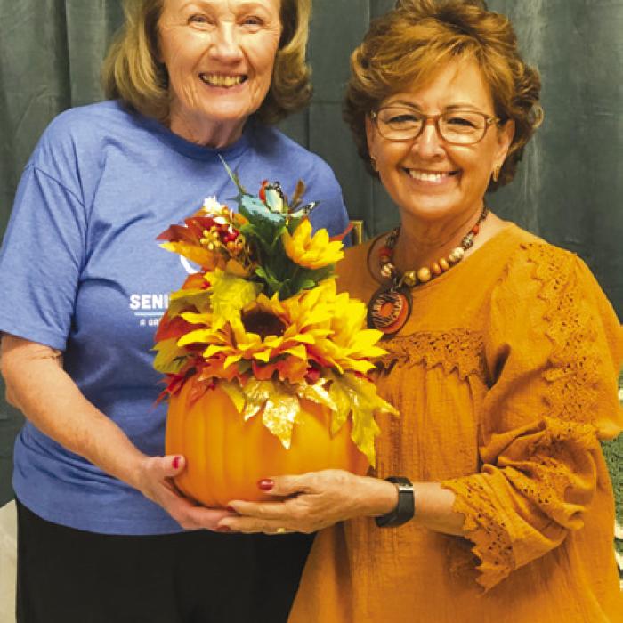 Matha Beckmann, right, is helping to welcome fall with the blackout price she created. Sharon Rodriguez, left was the lucky winner.
