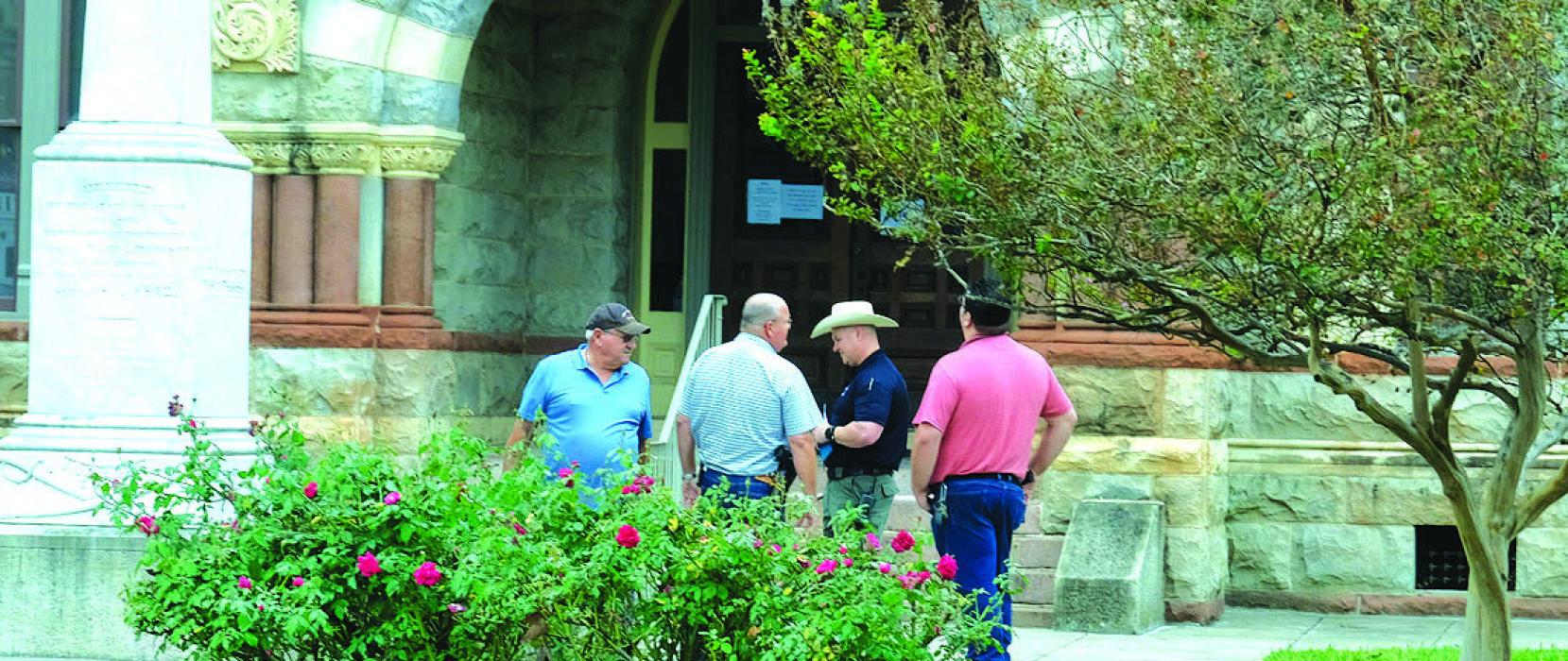 Deputies with the Fayette County Sheriff’s Office meet outside the Courthouse in La Grange on Wednesday morning during their investigation into a burglary at the Courthouse. Photo by Andy Behlen