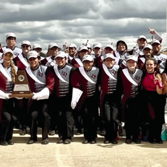 The band pictured with their UIL Division 1 Trophy at Giddings.