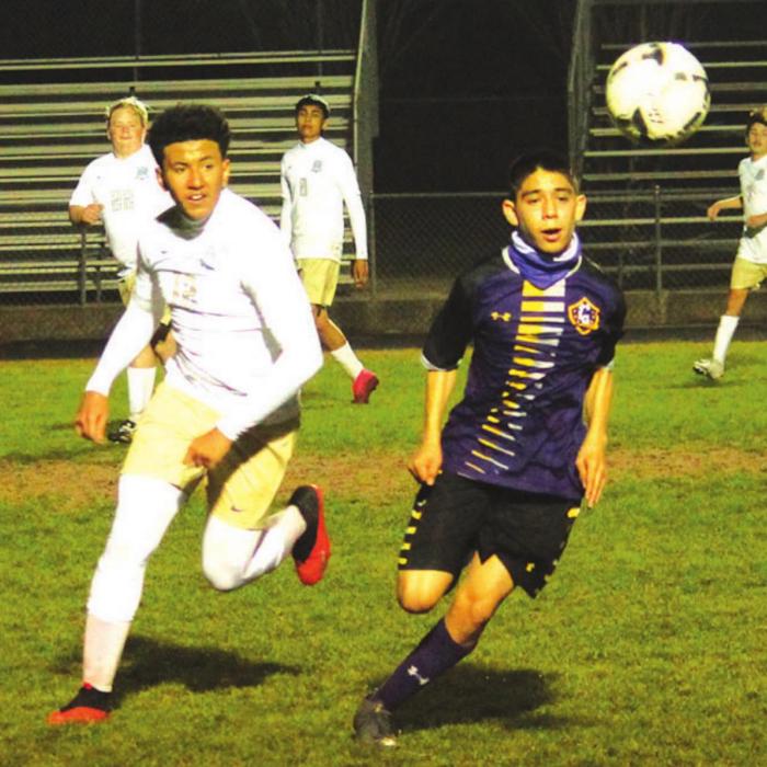 La Grange’s Johnny Vazquez races a Rockdale player to the ball in district soccer action Friday night at Leopard Stadium. Photo by Jeff Wick