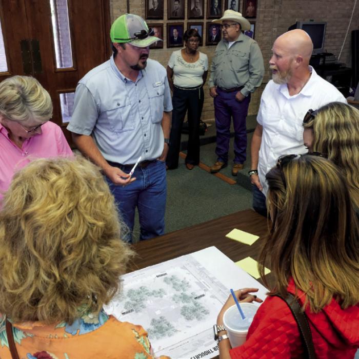 La Grange City Manager Jack Thompson (in white) speaks with attendees during a break-out session following the presentation.