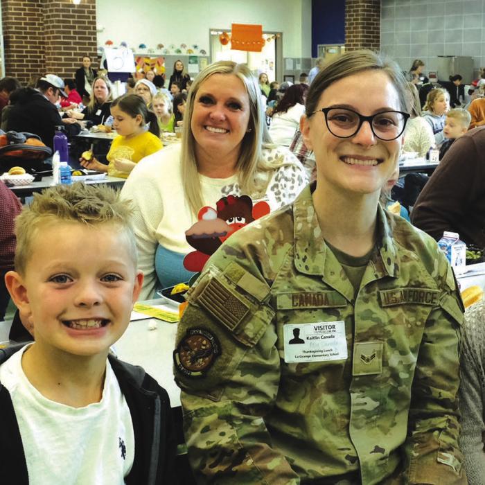 La Grange second grader Dawson Canada and third grader Ally Canada sit on either side of their sister Kaitlin Canada, Airman First Class, when she surprised them at school for lunch last week. Behind them are parents Wes and Brittany Canada.