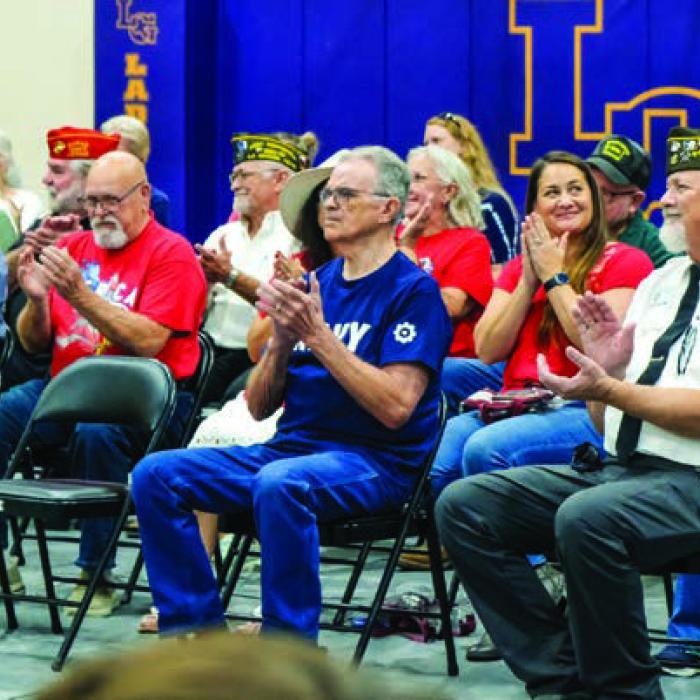 Veterans and their family members applaud following a performance of patriotic music by the Mighty Leopard Band during the program Monday.