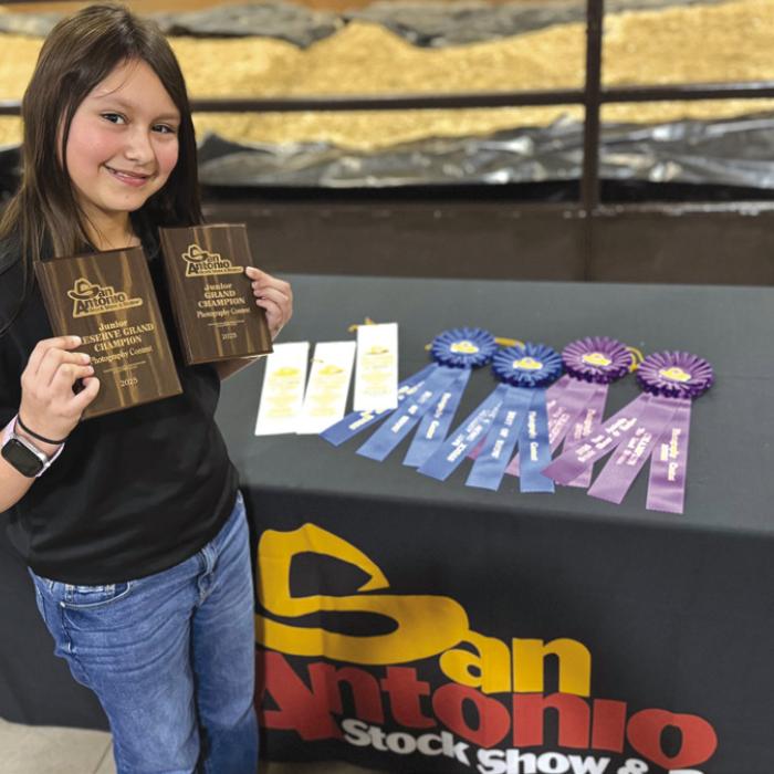 Elyse McBroom pictured with all of her awards from the San Antonio Stock Show and Rodeo Photography Contest.