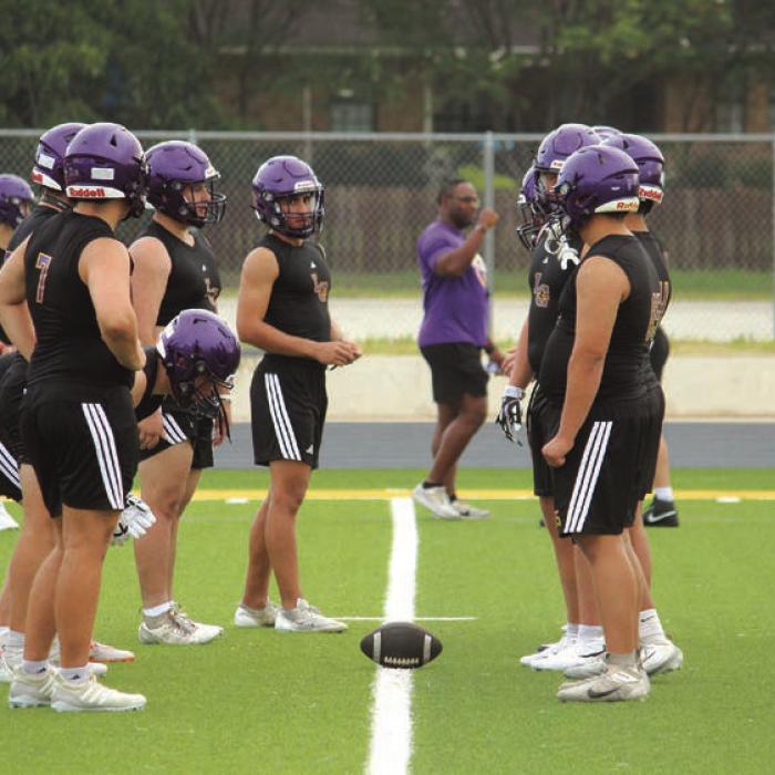 Members of the La Grange varsity football team walk through some formations Tuesday morning.