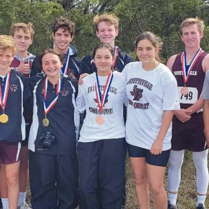 The Fayetteville boys and girls varsity cross country runners with their medals.