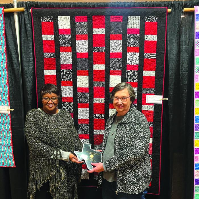 A quilt by Barbara Schellberg of La Grange called “Black, White and Red All Over” was chosen as The Pride of La Grange winner in the artisan category at this year’s Best Little Quilt Show in Texas. Schellberg is shown here, right, accepting the award from La Grange mayor Jan Dockery, left. Photos by Jeff Wick