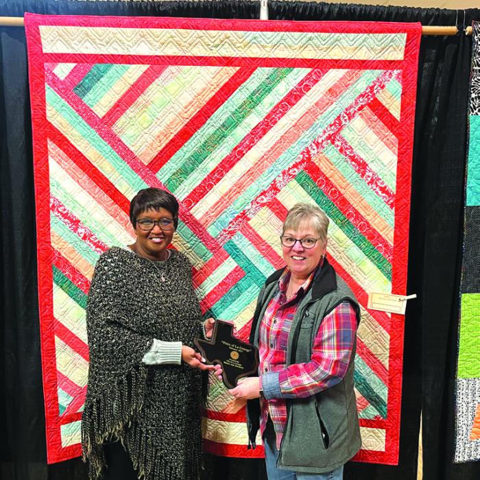 A quilt by Sandy Courrier of Muldoon called “Peaches ad Cream” was chosen as The Pride of La Grange winner in the professional category at this year’s Best Little Quilt Show in Texas. Courrier is shown here, right, accepting the award from La Grange mayor Jan Dockery, left. * Both of these quilts are Day 1 Bag Quilts, which means they will be given to kids in foster care when they graduate high school. The Day 1 Bag effort is getting 26 quilts from the local Colorado Valley Quilt Guild.