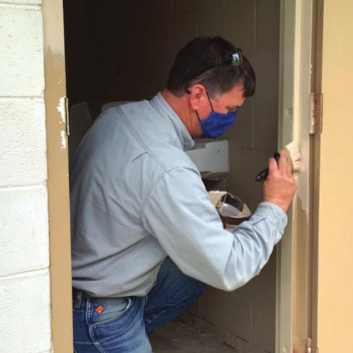 An LCRA employee paints a restroom at Northside Park in La Grange during LCRA’s Steps Forward Day on April 9. During the annual day of service, employees worked on more than 30 community projects.