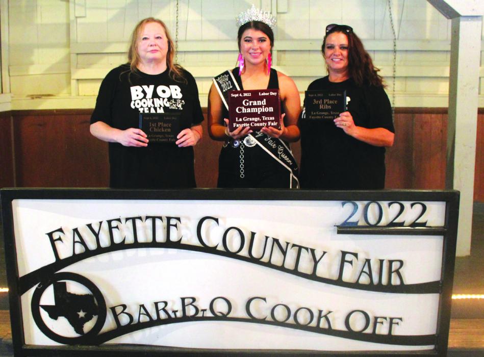 For the first time in recent memory, it was an all-women’s team that won the top honors at this year’s Fayette County Fair Bar-B-Q Cook-Off. The team of “BYOB All-In” of La Grange was crowned grand champion from among the 48 teams competing. Pictured above, left to right is head cook Gina Adams, Fair Queen Teagan Branch, and fellow cook Andrea Combs. More of the Bar-B-Q winning teams from the fair are pictured on Page D4 today. Photo by Jeff Wick
