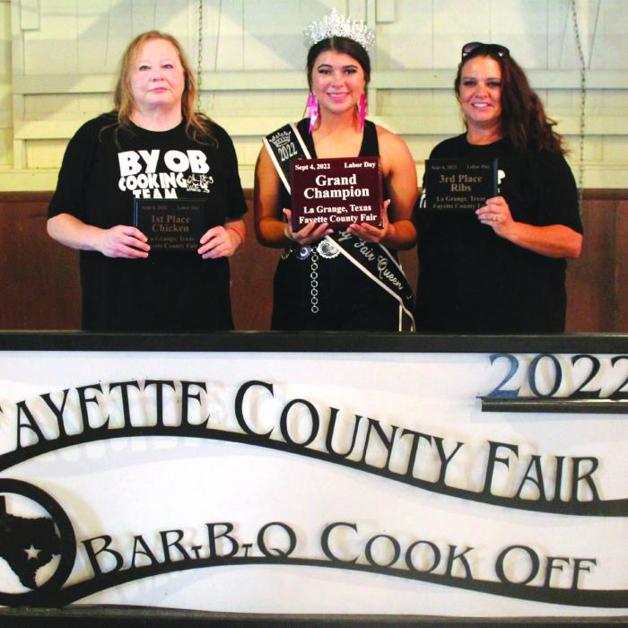 For the first time in recent memory, it was an all-women’s team that won the top honors at this year’s Fayette County Fair Bar-B-Q Cook-Off. The team of “BYOB All-In” of La Grange was crowned grand champion from among the 48 teams competing. Pictured above, left to right is head cook Gina Adams, Fair Queen Teagan Branch, and fellow cook Andrea Combs. More of the Bar-B-Q winning teams from the fair are pictured on Page D4 today. Photo by Jeff Wick
